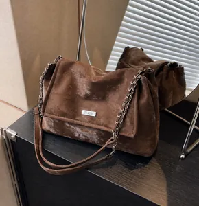 Detail of vintage dark brown crossbody bag with matte finish and metallic chain strap