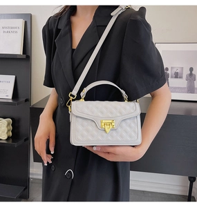 Détails du sac à main gris matelassé avec fermoir doré et surpiqûres élégantes