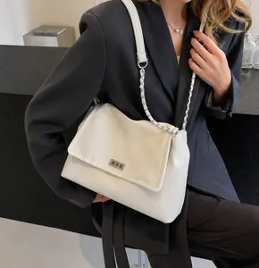 Detail of cream crossbody bag with silver logo plate and metal chain leather strap