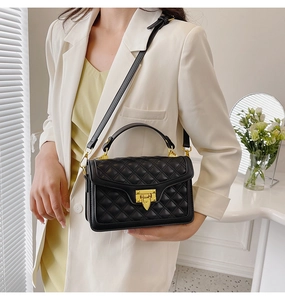 Détail d'un sac à bandoulière matelassé noir pour femme avec finitions dorées sur mannequin