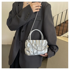 Detail of silver pleated cloud bag with metallic finish and delicate metal chain strap