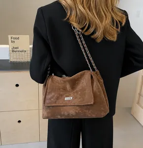 Detail view of the brown retro leather shoulder bag with silver chain strap on model