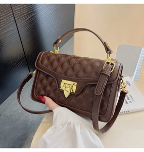 Détail du mini sac bandoulière matelassé marron foncé avec fermoir doré et poignée chic