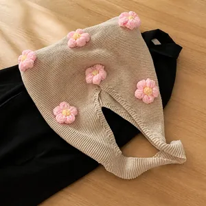 Detail of handmade crochet tote bag with pink 3D flower decorations on beige knit fabric
