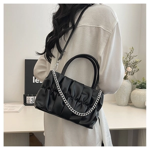 Close-up of black pleated crossbody bag with silver chain and leather strap
