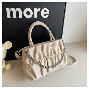 Close-up of cream pleated shoulder bag with silver chain and textured PU leather finish