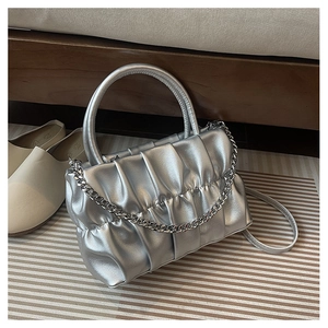 Detail of silver pleated handbag featuring metallic finish and decorative thick chain