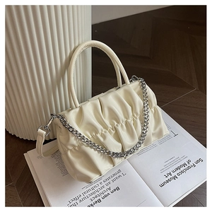 Detail of ruched cream leather handbag with silver chain and elegant handle