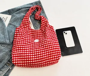 Detail showing red and white checkered canvas tote texture with a circular good patch