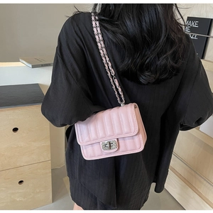 Detail of pink quilted shoulder bag featuring silver crystal-encrusted twist lock