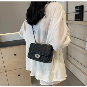 Rear view of black quilted crossbody bag with silver twist lock and metal chain strap