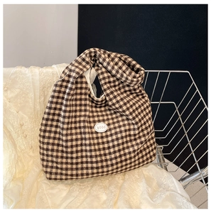 Detail of vintage brown checkered tote bag with good label and knotted canvas handle