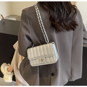 Silver metallic quilted crossbody bag with rhinestone twist lock shown on model