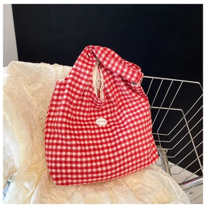 Close-up of red and white checkered canvas tote bag with soft fabric and good text patch