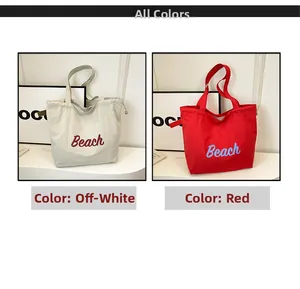 Detalle de bolsos tote de lona con letras Beach y cierre de cordón en blanco y rojo