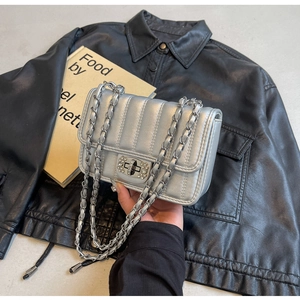 Detail of silver metallic quilted bag with crystal-encrusted twist lock and chain strap