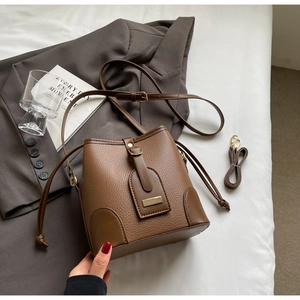 Detailed view of a brown vintage bucket bag with litchi texture and gold hardware