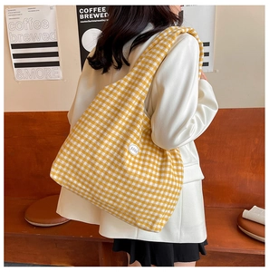 Close-up of yellow and white checkered canvas tote bag with good patch on the shoulder