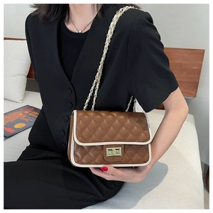 Vista dettagliata di una borsa a tracolla trapuntata marrone con elegante bordo bianco.