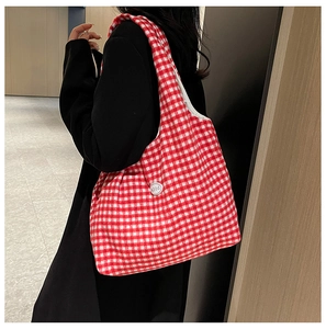 Detail of red and white gingham fabric tote bag with a branded white button decoration