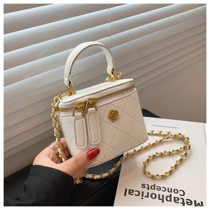 Primer plano detallado de mini bolso acolchado blanco con cadena de oro y flor