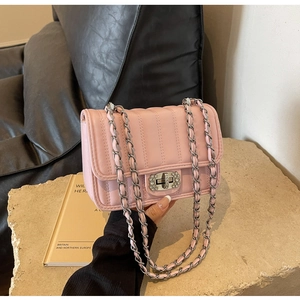 Detail of pink quilted handbag with rhinestone swivel lock and silver chain strap