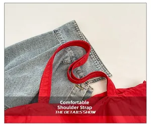 Detalle de la correa ancha y cómoda en el bolso tote grande de nailon rojo para mujer