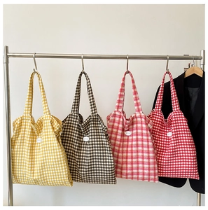 Detailed row of checkered tote bags in yellow, pink, and black colors on hangers