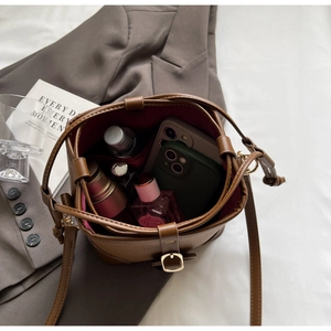 Top view of brown leather bucket bag showing internal capacity for phone and cosmetics