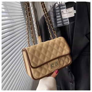 Dettaglio borsa a tracolla trapuntata beige con bordo marrone e chiusura a girello