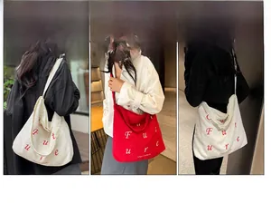 Dettaglio di borse tote in velluto a coste bianco e rosso con scritta Future