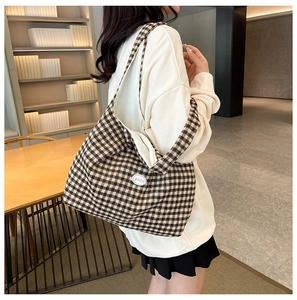 Detail of checkered tote bag with vintage brown pattern and circular brand patch