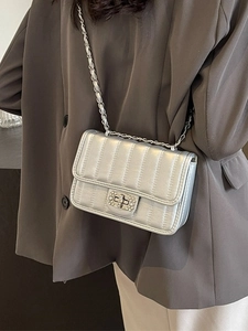 Silver quilted chain square bag with diamond twist lock worn by a model