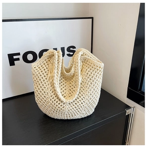 Vue détaillée du sac cabas au crochet beige avec maille texturée et pompon décoratif