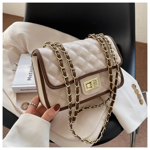 Dettaglio borsa trapuntata beige con bordi marroni e chiusura a girello dorata