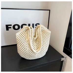 Détail du sac tissé crème avec texture en maille ajourée et double poignée