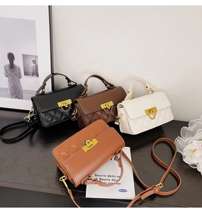 Nahaufnahme von vier gesteppten Handtaschen in Schwarz, Braun und Weiß mit Golddekor