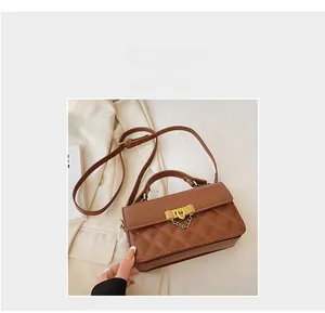 Details der braunen Stepptasche mit orangen Nähten und goldenem Metallschloss