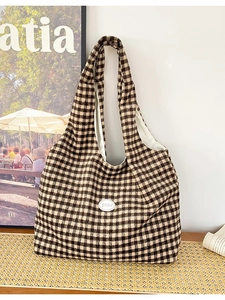 Large black and white checkerboard tote bag with good letter patch on white wall