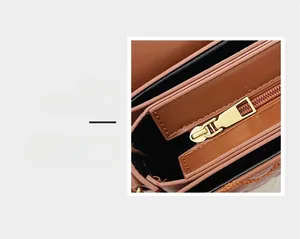 Detail eines goldenen Reißverschlusses und braunem Leder an einer Vintage-Umhängetasche