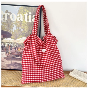 Close-up of red and white gingham canvas tote bag with a stitched good label