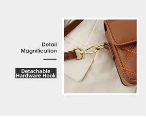 Detailansicht des abnehmbaren goldenen Metallhakens an einer braunen Stepptasche