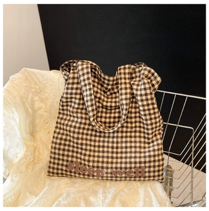 Detailed view of checkered tote bag fabric with Sleep Well text and canvas texture