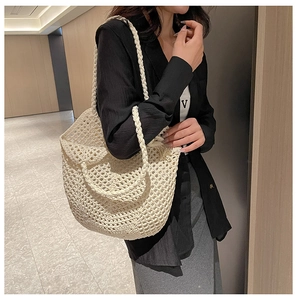 Détail d'un sac cabas tissé crème avec texture en crochet ajouré et doubles lanières