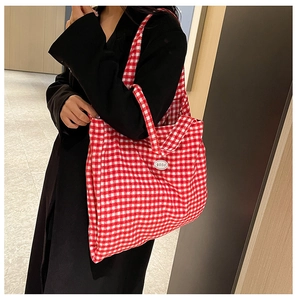 Detail of red and white gingham canvas tote bag with a minimalist good logo patch