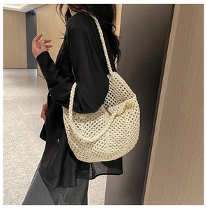 Détail de la texture d'un sac cabas ajouré ivoire avec une bandoulière tressée