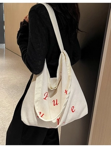 Borsa tote in velluto a coste bianco crema con ricamo Future rosso indossata da modella