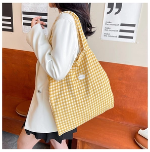 Detail shot of yellow gingham canvas tote bag featuring an oval good logo patch
