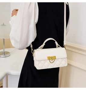 Rückansicht von Model mit weißer gesteppter kleiner Tasche mit goldenem Schloss und Kettenriemen