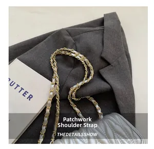 Detailed close-up of the silver quilted leather texture and metal chain strap on handbag